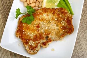 Pork schnitzel on the plate and wooden background photo