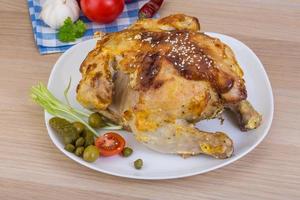 Grilled chicken on the plate and wooden background photo