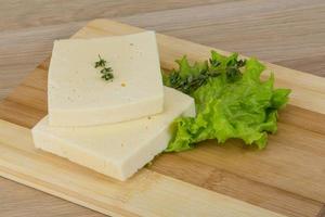 Yellow cheddar on wooden board and wooden background photo