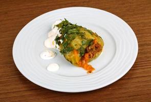 Stuffed pepper on the plate and wooden background photo