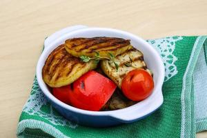 Grilled vegetables in a bowl on wooden background photo