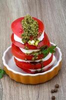 Caprese salad in a bowl on wooden background photo