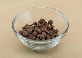 Black pepper in a bowl on wooden background photo