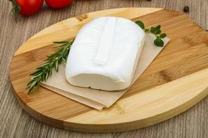 Feta cheese on wooden board and wooden background photo