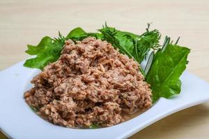 Cannded runa in a bowl on wooden background photo