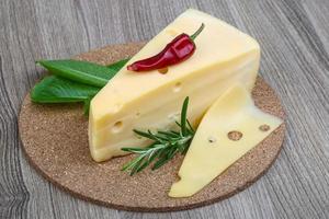 Yellow cheese on wooden board and wooden background photo