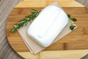 Feta cheese on wooden board and wooden background photo