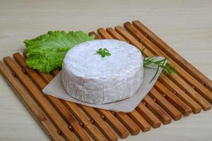 Camembert cheese on wooden board and wooden background photo