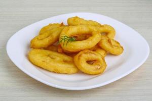 Calamari rings on the plate and wooden background photo