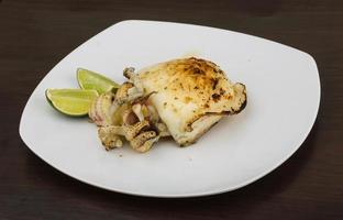 Grilled cuttlefish on the plate and wooden background photo