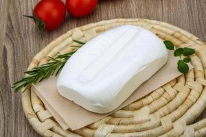 Feta cheese on wooden board and wooden background photo