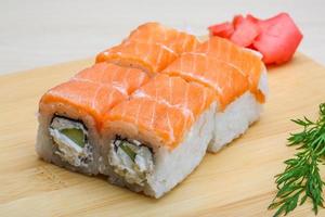 Philadelphia roll on wooden board and wooden background photo