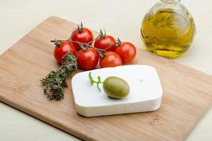 Feta cheese on wooden board and wooden background photo