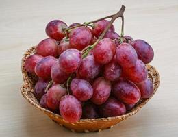 Red grape in a basket on wooden background photo