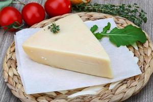 Parmesan cheese on wooden board and wooden background photo