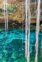 Blue turquoise water limestone cave sinkhole cenote Tajma ha Mexico. photo