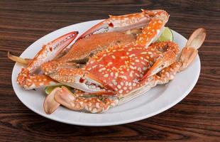 Boiled crabs on the plate and wooden background photo