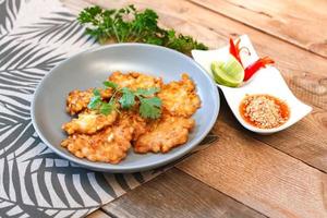 Corn Fritters With chili sauce placed on a wooden table photo