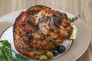 Pork knee on the plate and wooden background photo