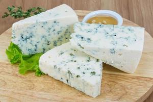 Blue cheese on wooden board and wooden background photo