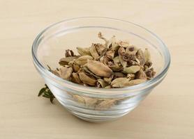 Cardamom in a bowl on wooden background photo
