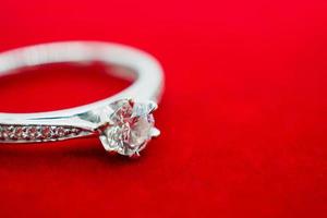 close up luxury wedding diamond ring on red background photo