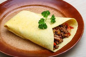 Burrito on the plate and wooden background photo