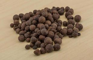 Black pepper on wooden background photo