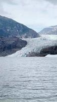 Panning view of ice and snow covered mountains surrounded by water and fog video