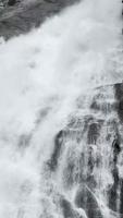 Panning up view of large flowing waterfall video