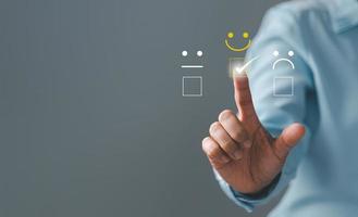 Customer service and Satisfaction concept, Excellent consumer feedback. Business people are touching virtual screen on happy Smiley face icon to give satisfaction in service. rating very impressed. photo