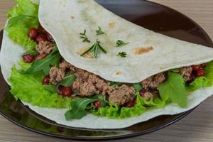 Burrito on the plate and wooden background photo