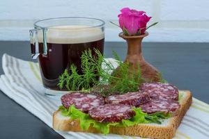 Salami sandwich on wooden background photo