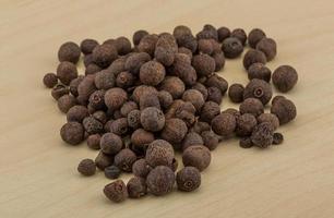Black pepper on wooden background photo