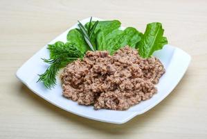 Cannded runa on the plate and wooden background photo