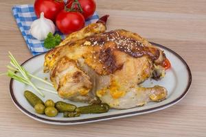 Grilled chicken on the plate and wooden background photo
