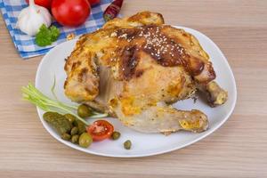 Grilled chicken on the plate and wooden background photo