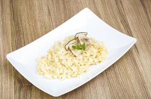 Mushroom risotto on the plate and wooden background photo