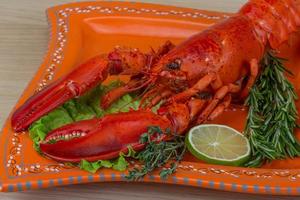 Boiled lobster on the plate and wooden background photo