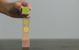 Satisfaction survey concept. Customer services best excellent business rating experience. Hand of business chooses a smile face on wood block circle. 5 Star Satisfaction. People feel great product. photo