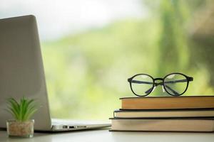 educación de objetos fondo de naturaleza verde con una pila de libros antiguos o biblia antigua, libro de papel abierto sobre una mesa de madera con espacio para copiar. concepto de regreso a la escuela, estudio de investigación foto