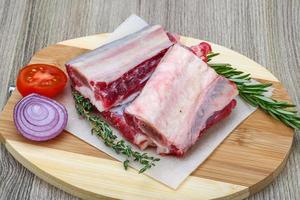 costillas de ternera sobre tabla de madera y fondo de madera foto