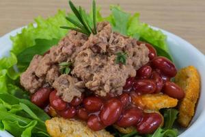 Tuna salad in a bowl on wooden background photo