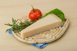 Parmesan cheese on wooden board and wooden background photo