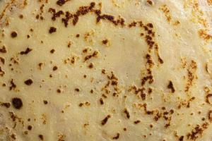 Pancake surface texture and pattern. Close-up of thin hot pancakes in a plate. Traditional rustic food. Graphic resource. photo