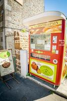 France, 2022 - Bread Red coin Machine on the side of the road with ledistribpain sign on it. Technologies and baguettes in France photo