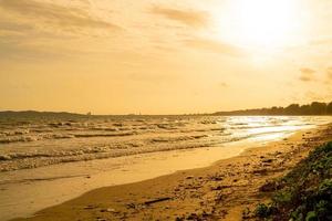 hermosa playa de mar con puesta de sol foto