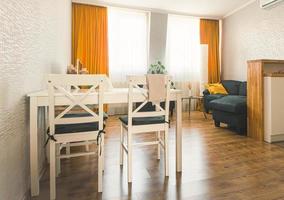 Cozy studio apartment kitchen with table sofa and bright interior autumn color palette photo