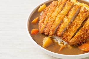 arroz al curry con chuleta de cerdo frita y tortilla cremosa foto