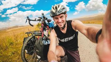 Caucasian male person takes selfie on bicycle vacation in scenic caucasus armenia mountains region. Travel in Armenia. photo